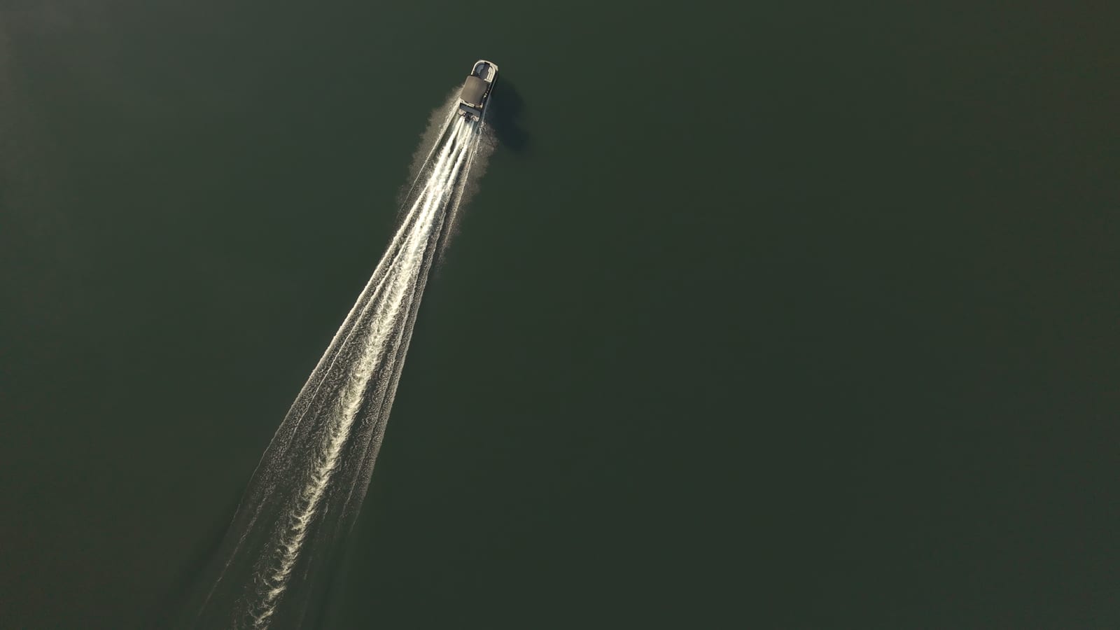 A boat wake on dark water